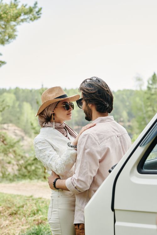 Free A young couple embracing lovingly outdoors on a sunny day, exuding romance and connection. Stock Photo