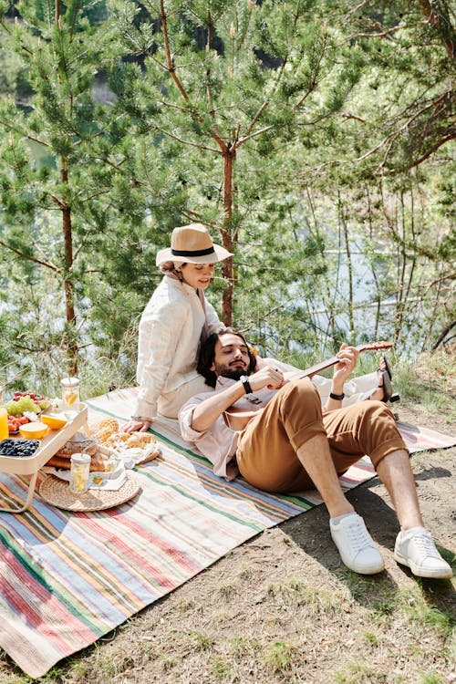 Man and Woman Sitting on Brown Wooden Picnic Table