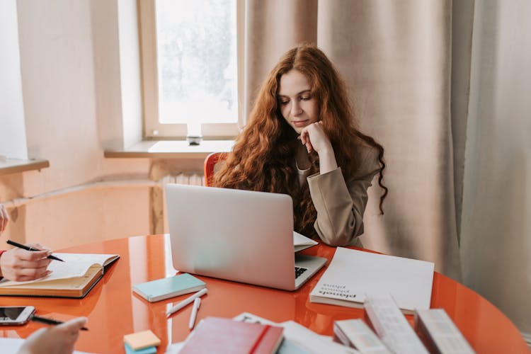 Redhead Woman Using A Laptop While Working In The Office