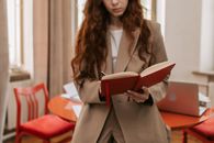 Woman in Brown Blazer Holding Book