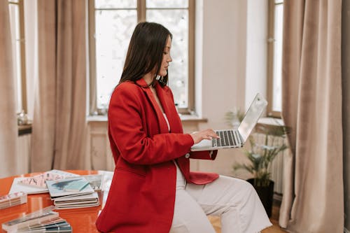 Woman in Red Blazer Using a Laptop