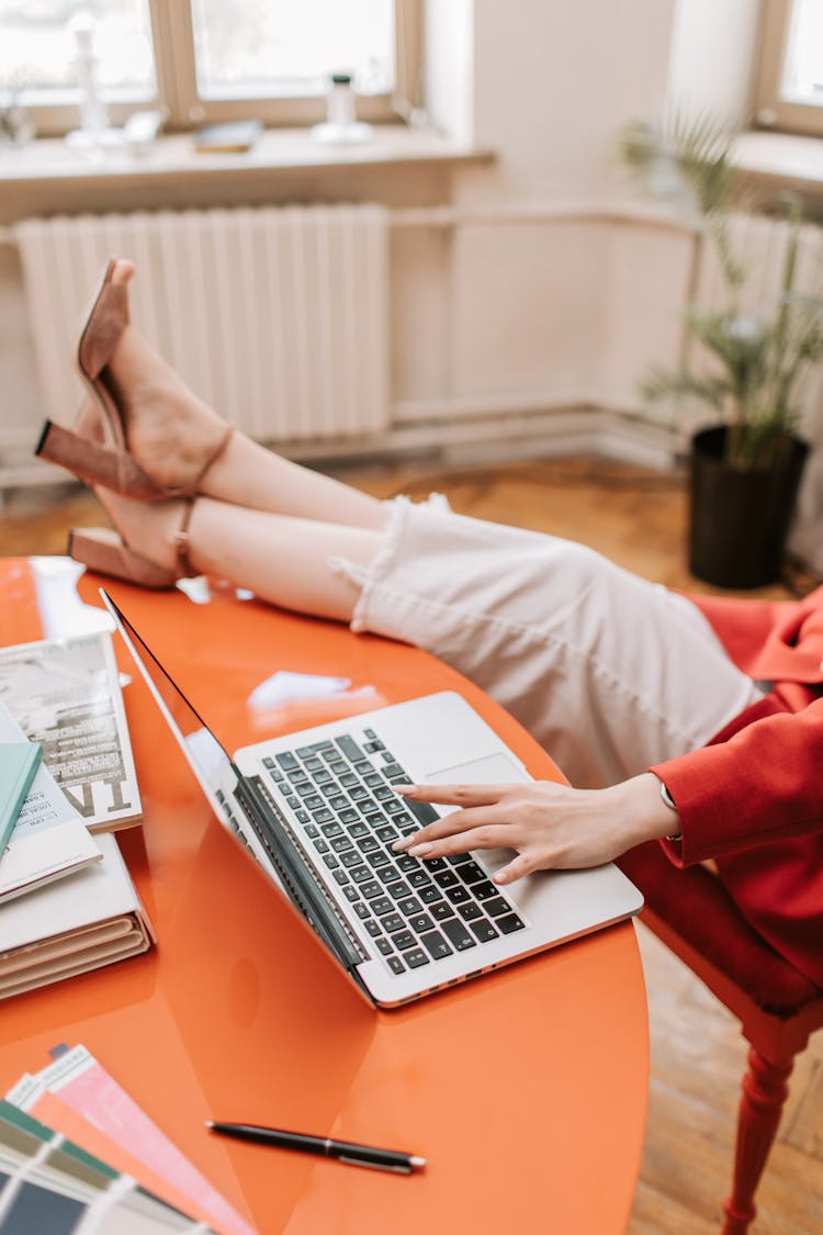 A Casual Person Using A Macbook Laptop