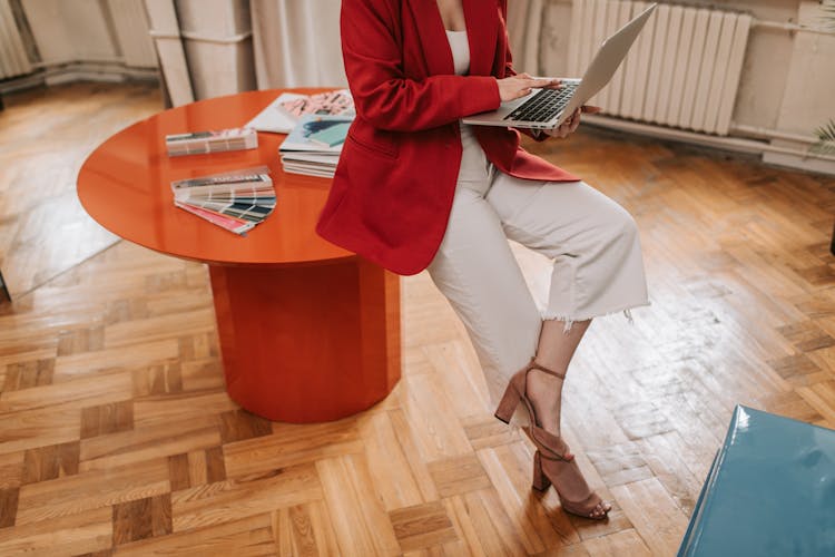 A Person Wearing A Red Blazer Using Laptop