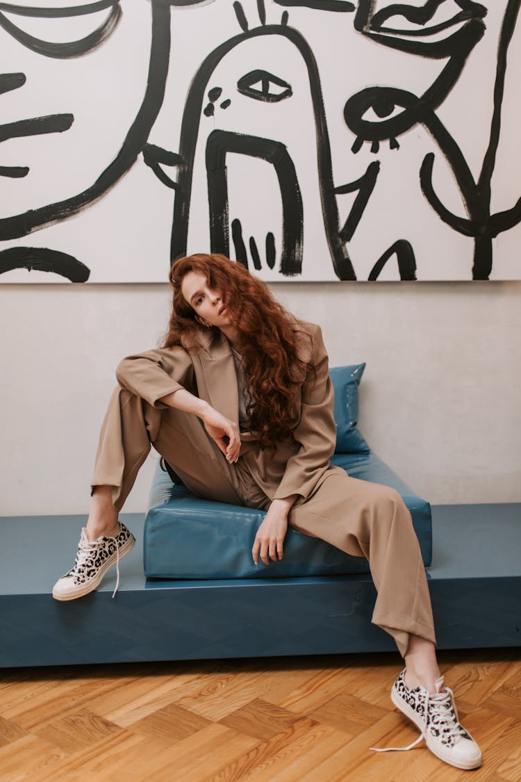 Woman In Beige Suit Sitting On The Couch