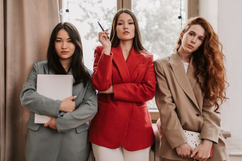 Free Three businesswomen in stylish blazers exuding confidence indoors. Stock Photo