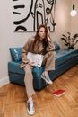 Woman in Brown Coat Sitting on Blue Couch