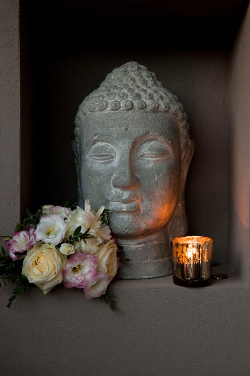 Buddha Head Statue with Flowers and Candle