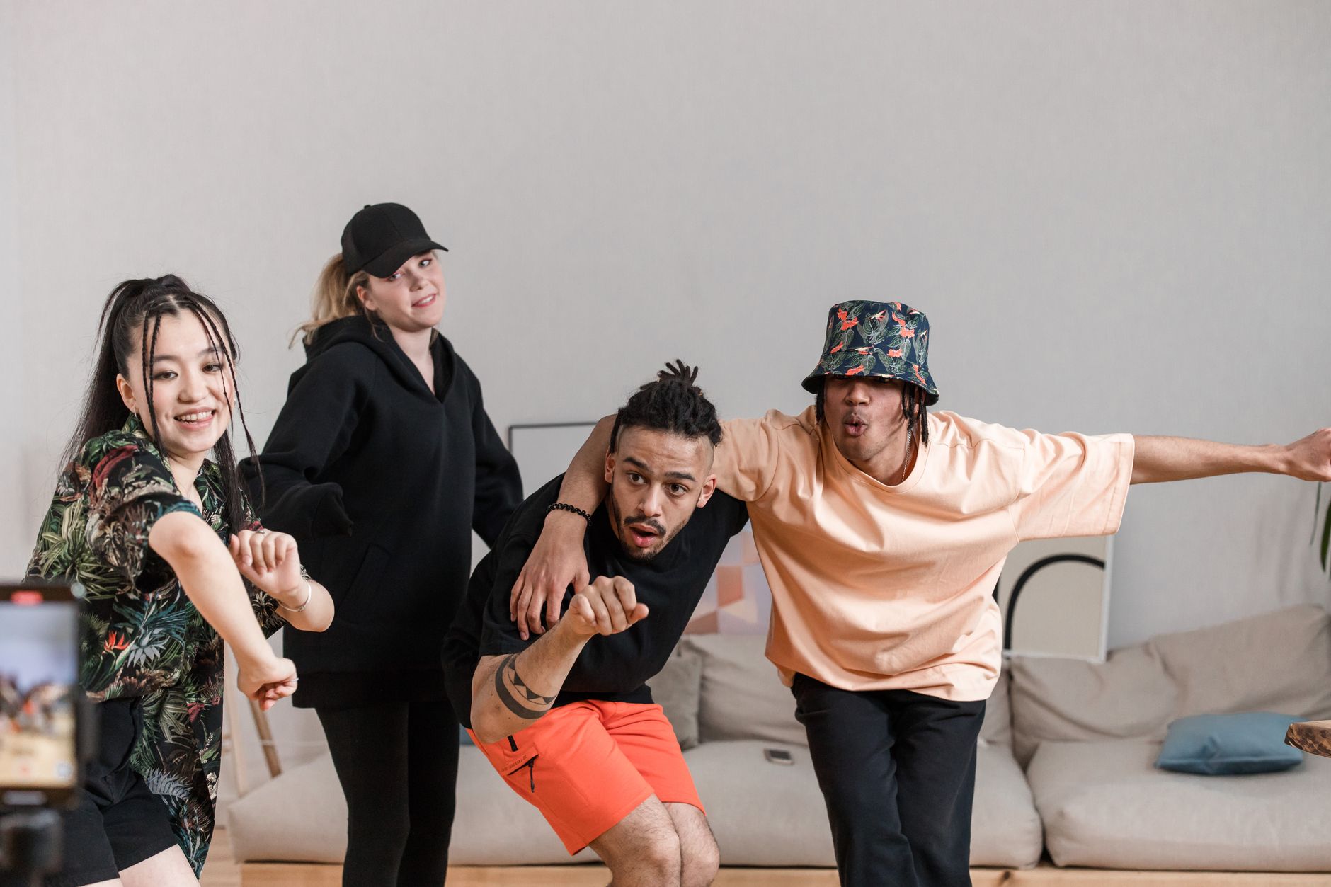 A vibrant group of friends dances energetically in a lively indoor setting on a cozy sofa.