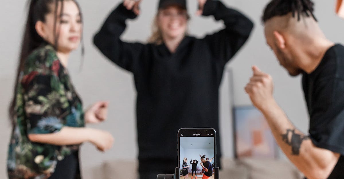 Energetic group of friends dancing and recording a video using a smartphone indoors. Social Media Marketing Trends.