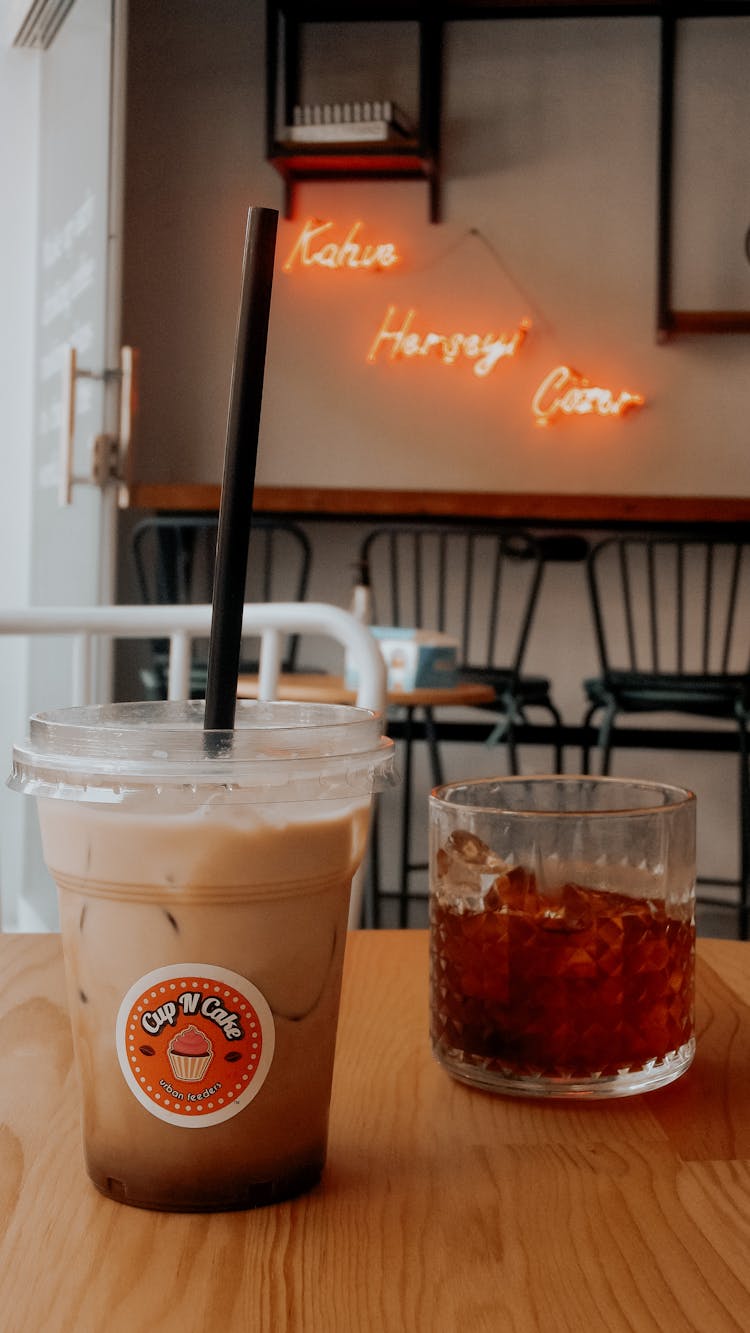 Plastic Cup Of Cold Coffee With Glass Of Alcoholic Drink