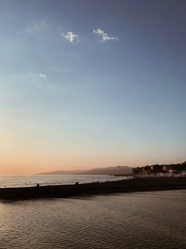 Tranquil sunset view over the ocean with soft pastel skies and gentle waves.