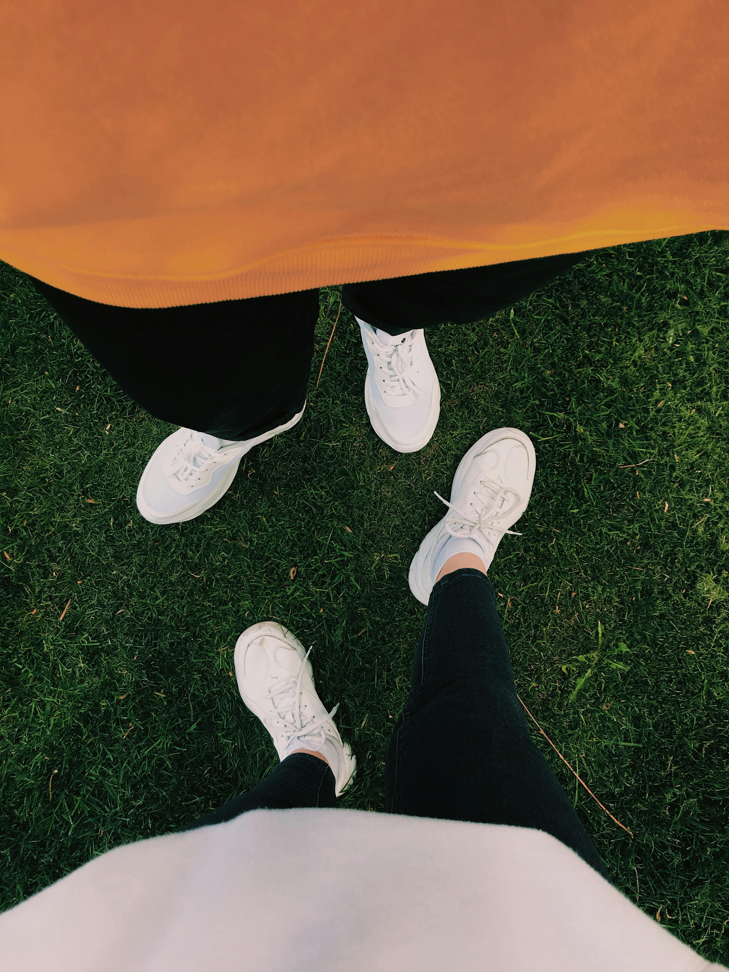 two people wearing white sneakers