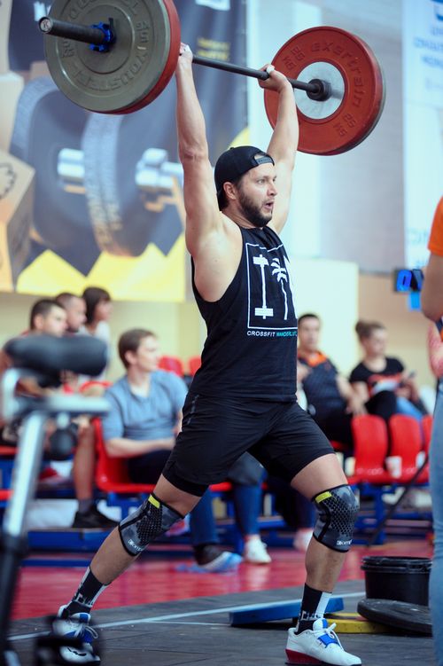 Free Athlete performing a weightlifting exercise at an indoor sports event. Stock Photo