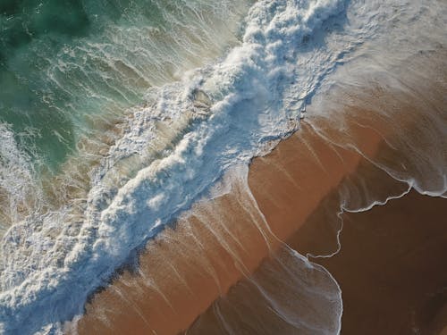 An Aerial Photography of Beach Waves Crashing on Shore