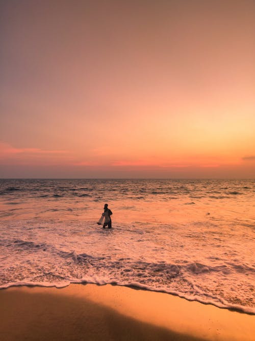 A Person in Body of Water during Sunset