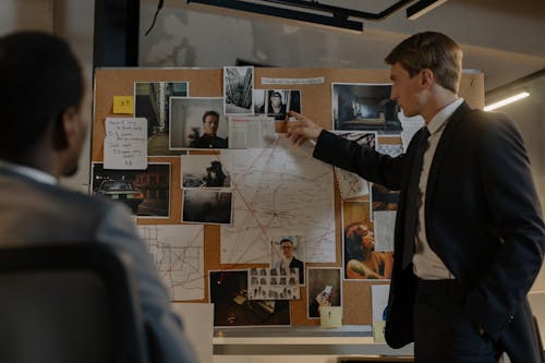 Free Detectives Looking at Evidences on Cork Board Stock Photo