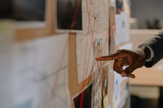 Close-Up Shot of a Person Pointing at Evidence Board