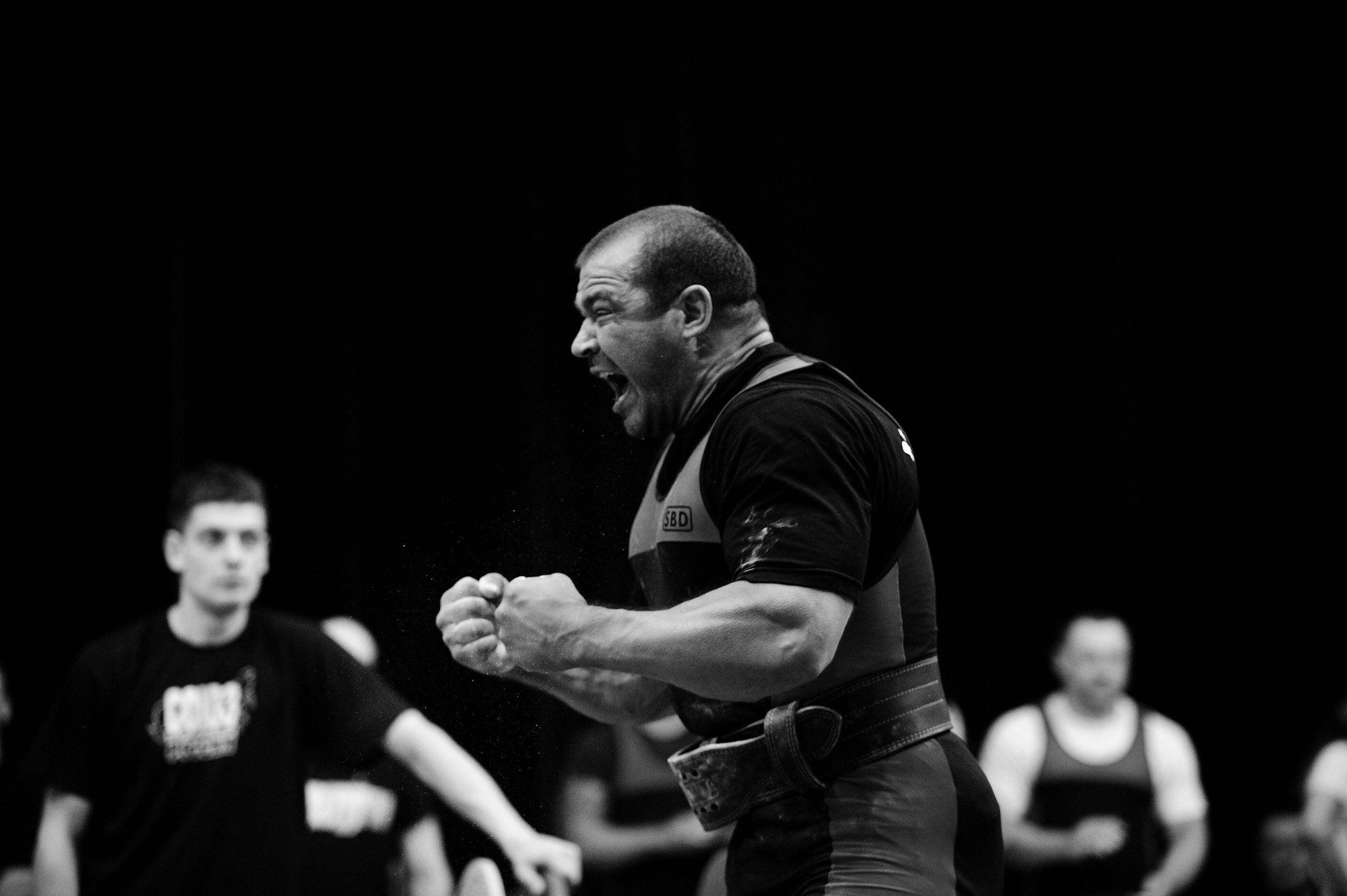 Powerlifter expressing intense emotion mid-competition. Captured in dramatic black and white.