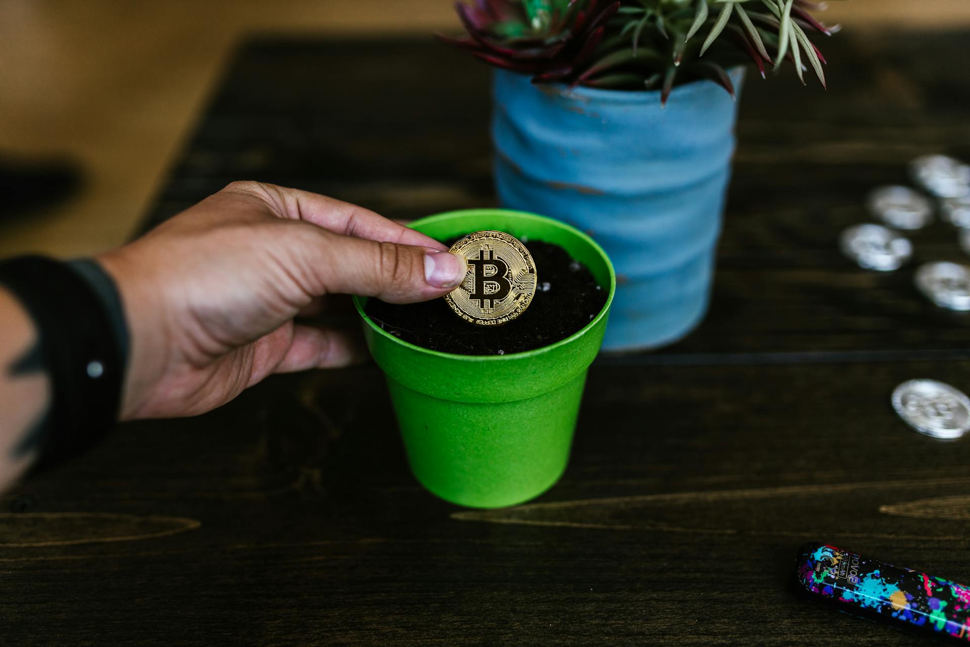 A bitcoin coin being placed into a green pot, symbolizing investment growth.