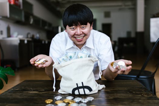 Asian man smiling with cryptocurrency coins and cash at home office setting.