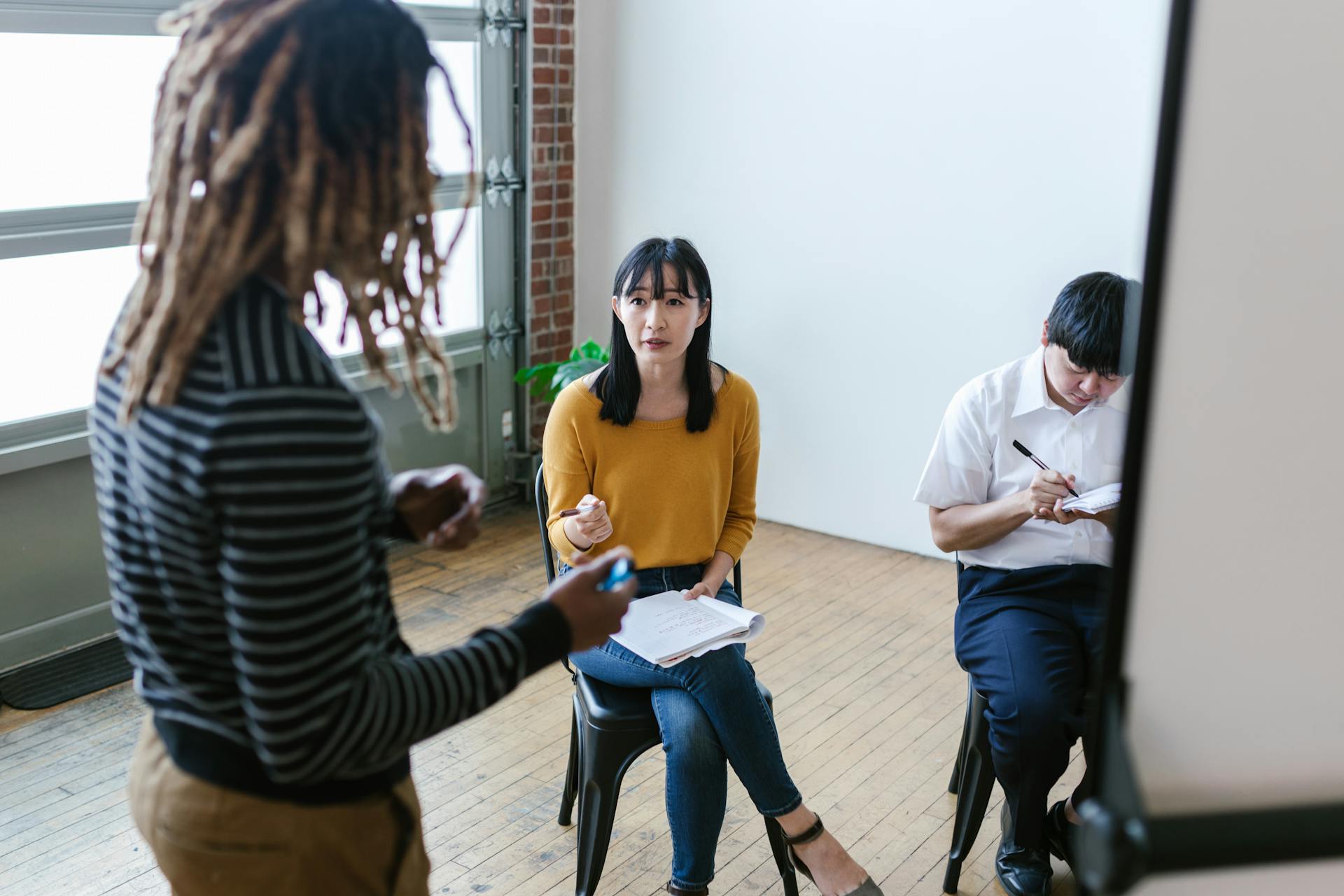 A group of professionals engaged in a lively discussion during a business meeting in a modern office setting.