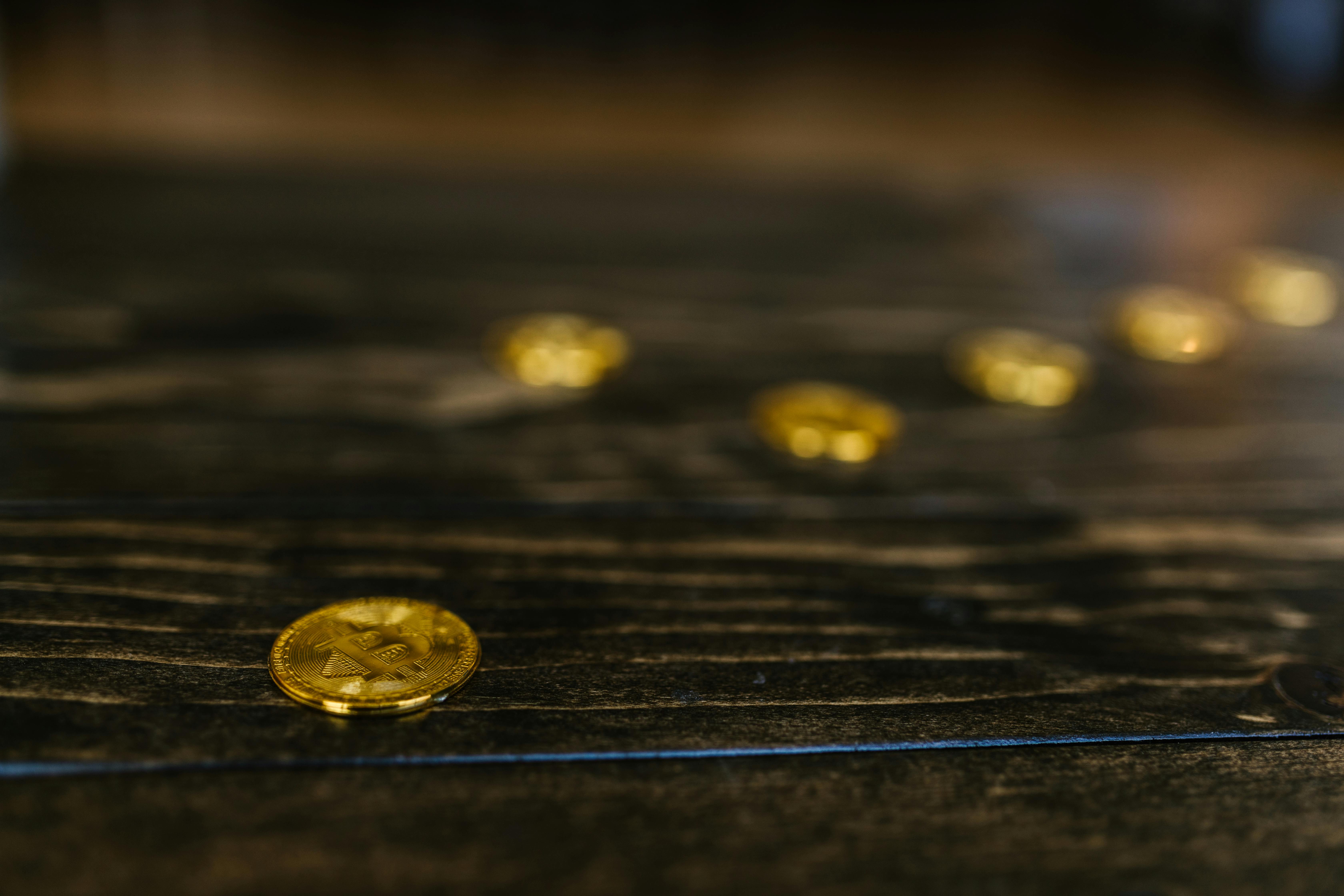 close up shot of gold bitcoin on wooden surface