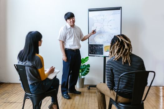 Three people in an indoor meeting discussing cryptocurrency and blockchain strategies.