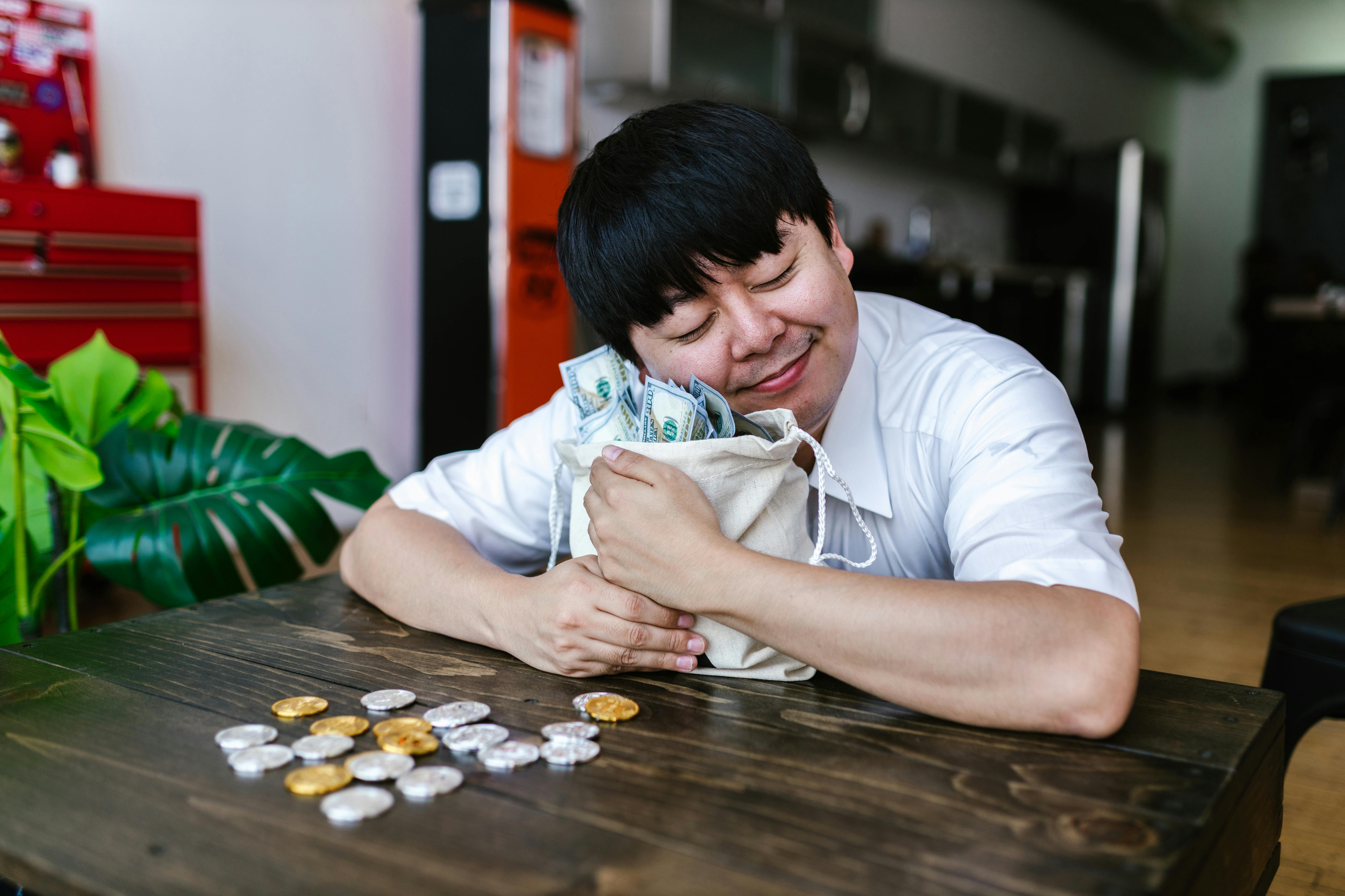 a man hugging a bag of cash money