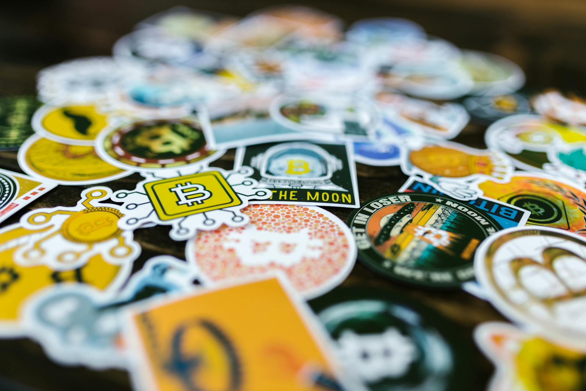 Heap of Bright Stickers with Bitcoin Logo Lying on a Table