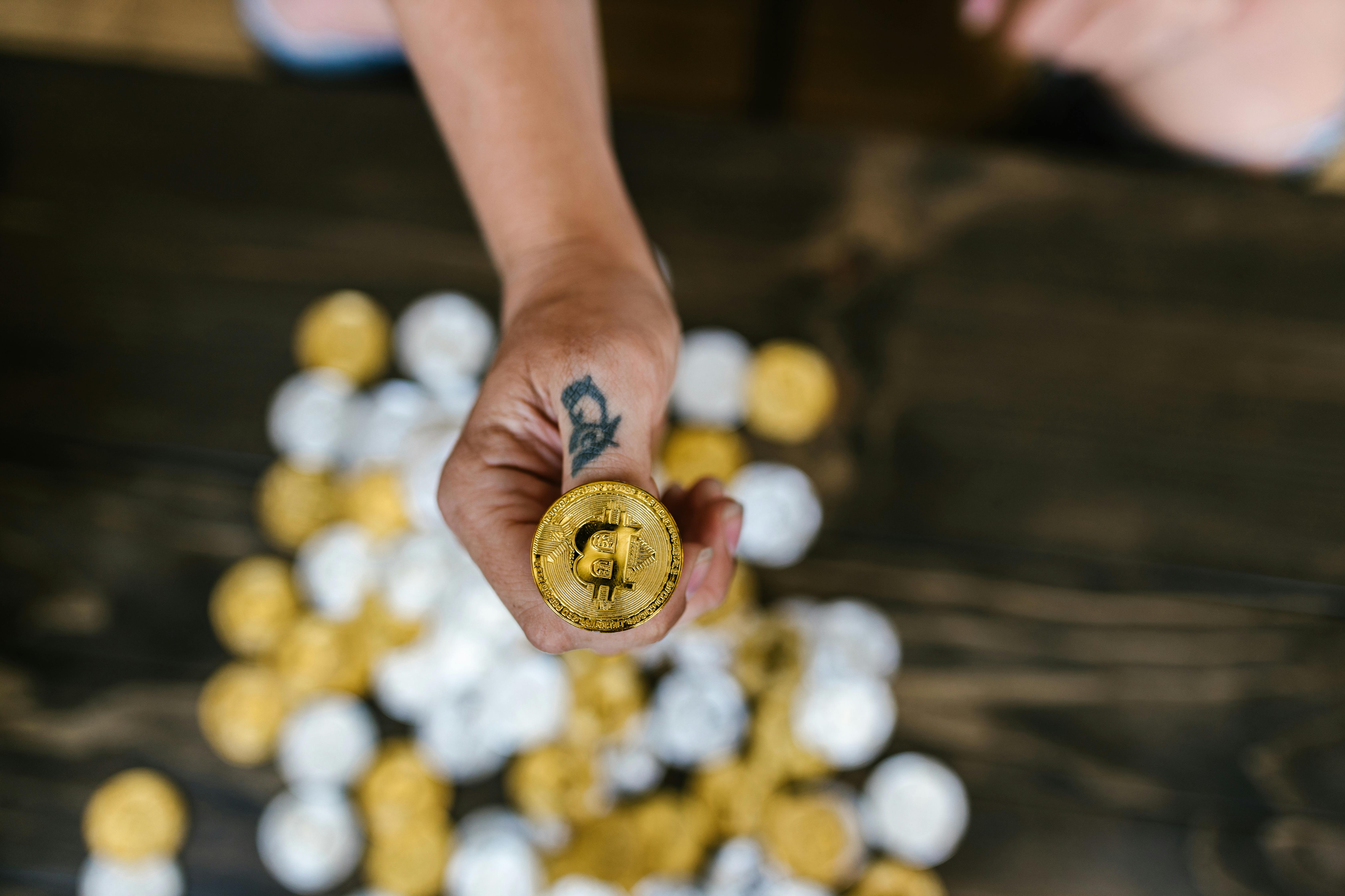 person holding gold round coins