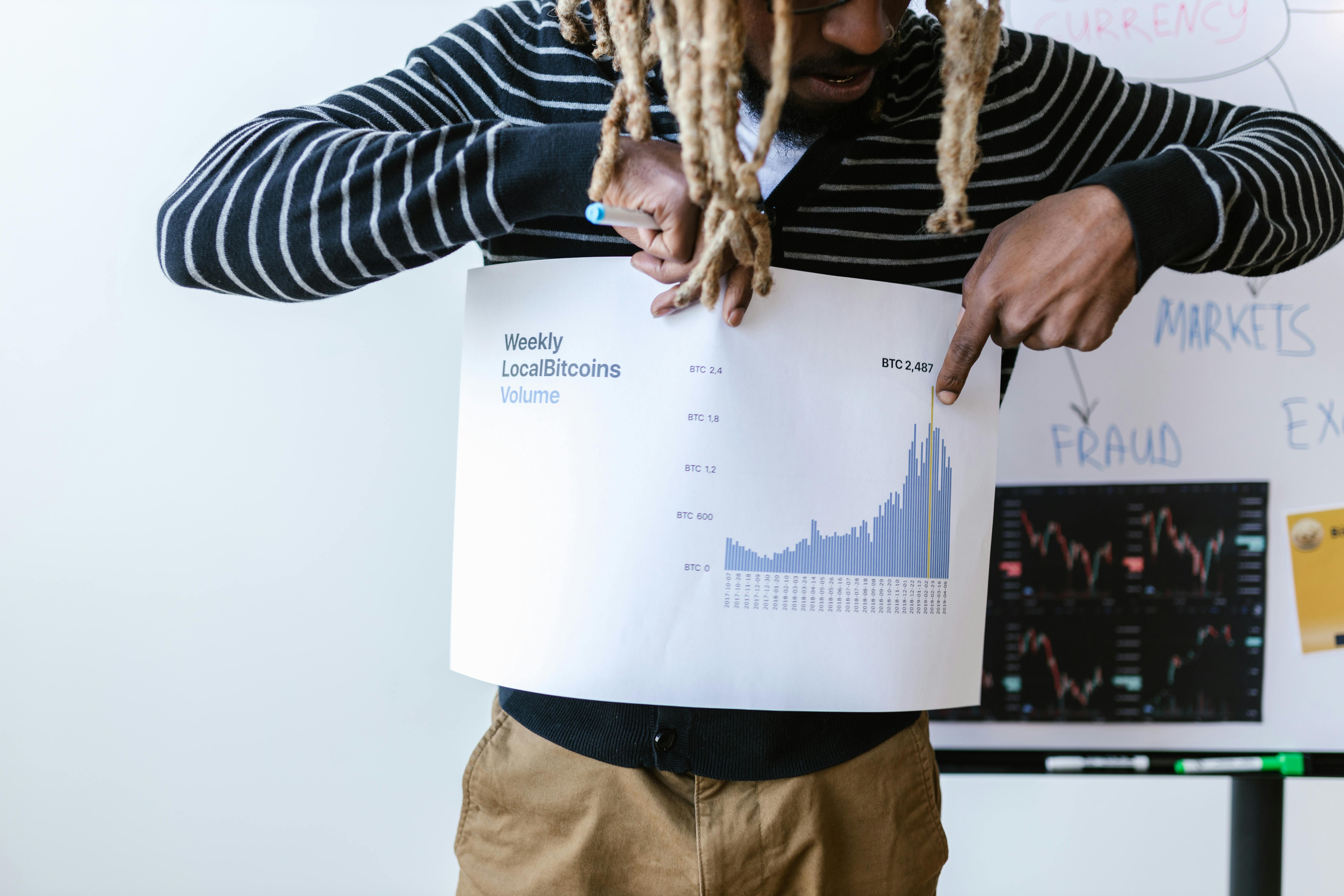 a man holding a paper about crytocurrency