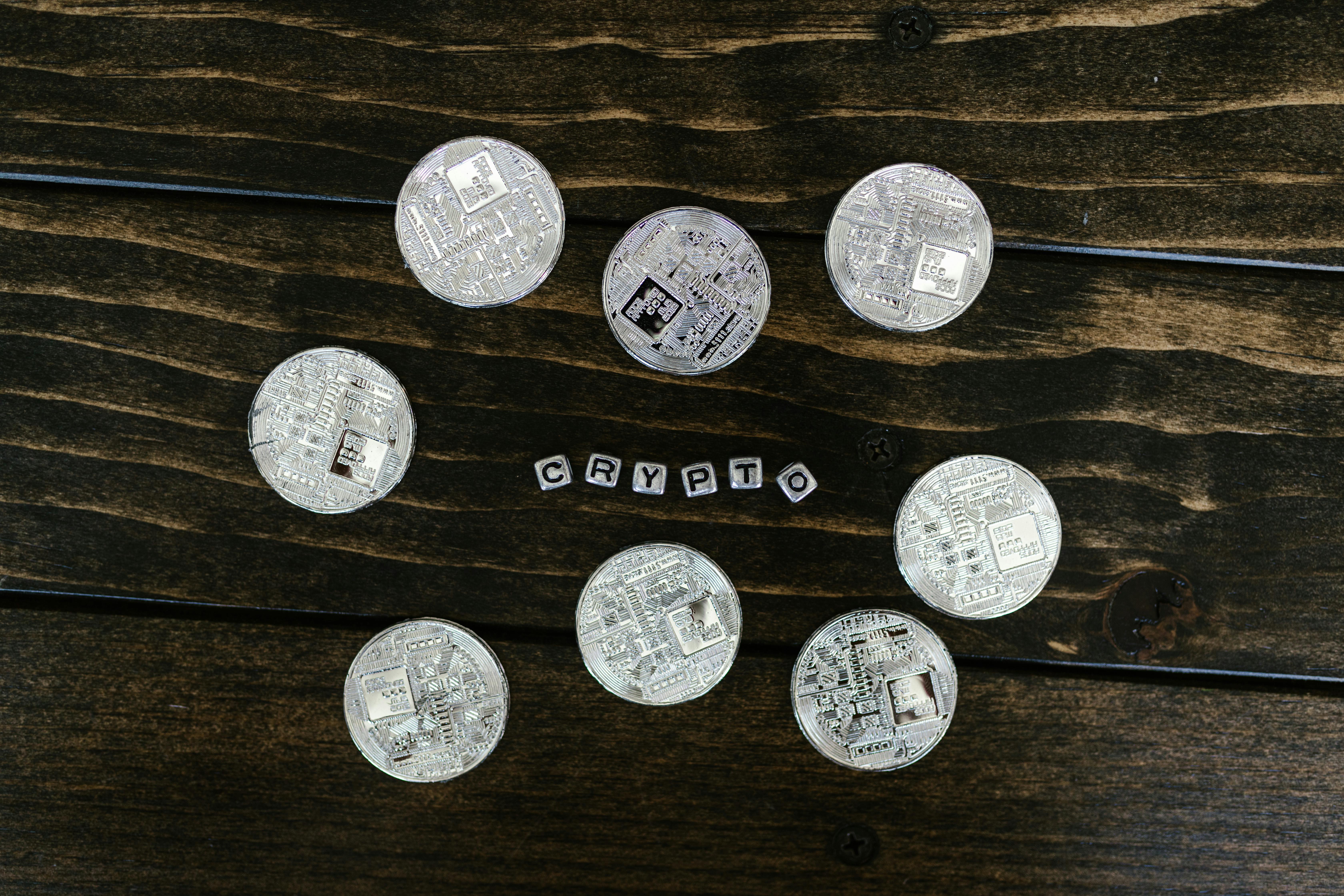 silver round coins on brown wooden surface