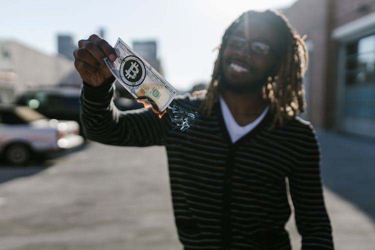 Man With Dreadlocks Holding A Burning Money