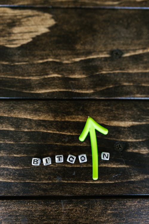 Free Letter Beads and Green Arrow on a Wooden Surface  Stock Photo