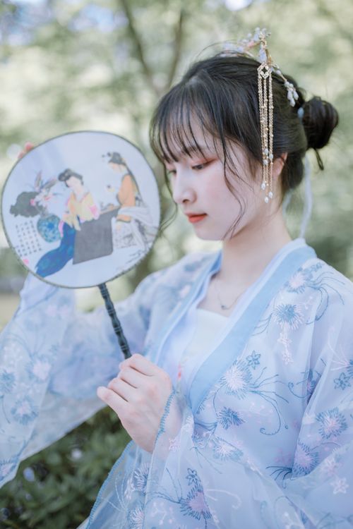 Free Beautiful Asian woman in traditional kimono with hand fan, set in a serene outdoor environment. Stock Photo