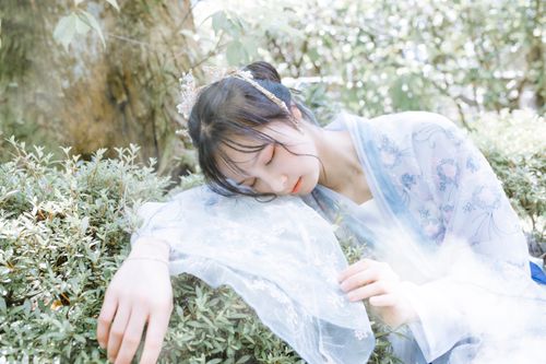 Free A peaceful image of a woman in a kimono, eyes closed, enjoying a sunny day among plants. Stock Photo