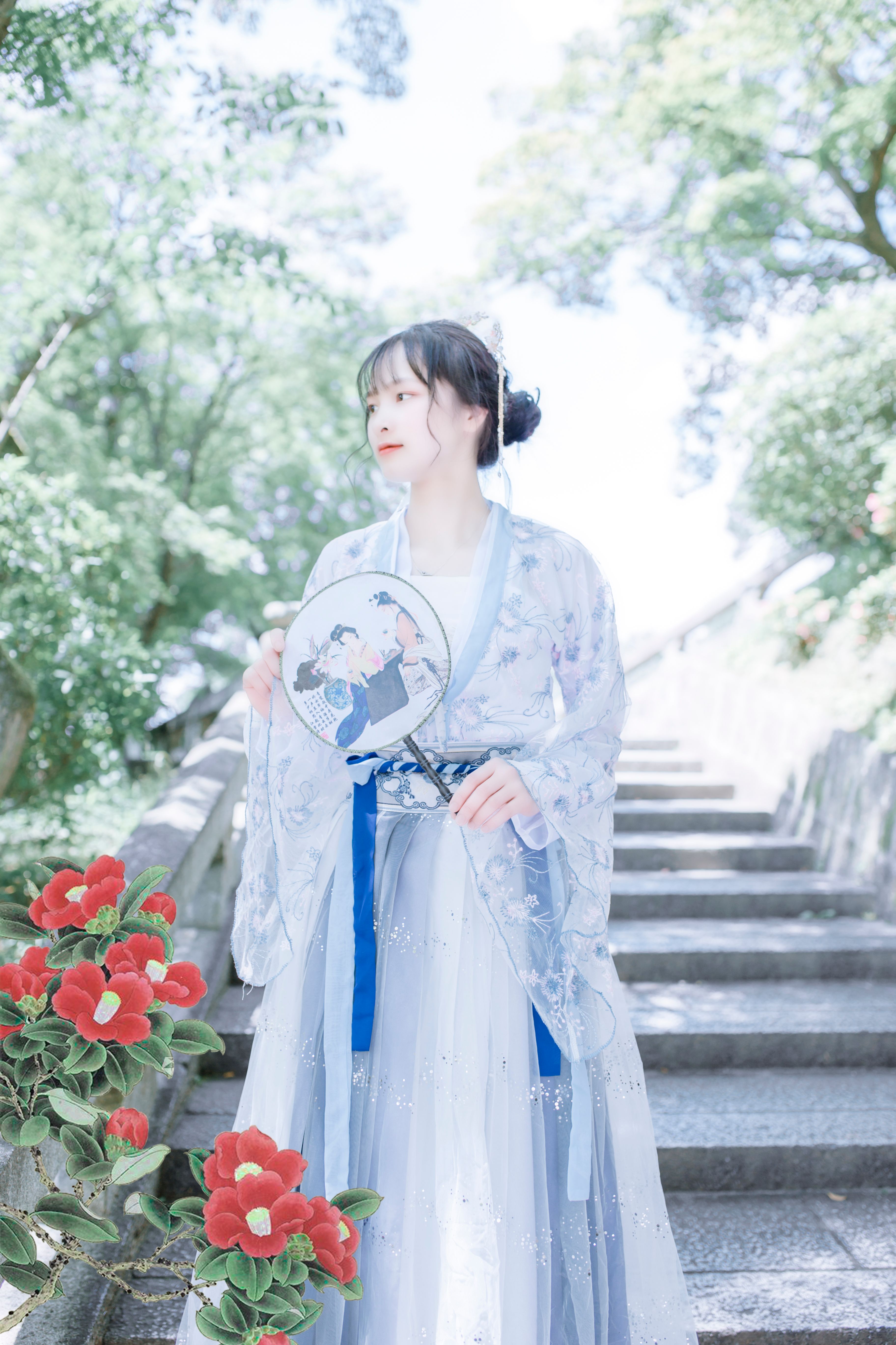 A serene image of a woman in a blue kimono with flowers on outdoor stairs.