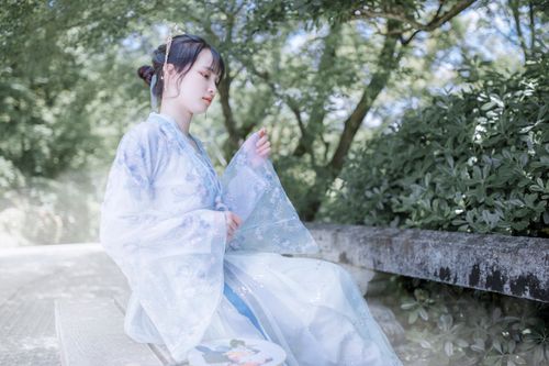 Free A young woman in traditional clothing sits peacefully on a bench, surrounded by nature. Stock Photo