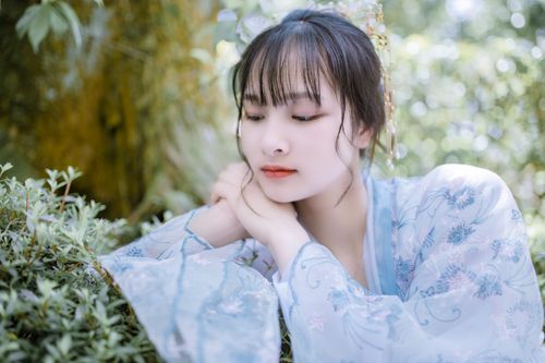 Free Beautiful woman in traditional clothing resting outdoors with lush greenery background. Stock Photo