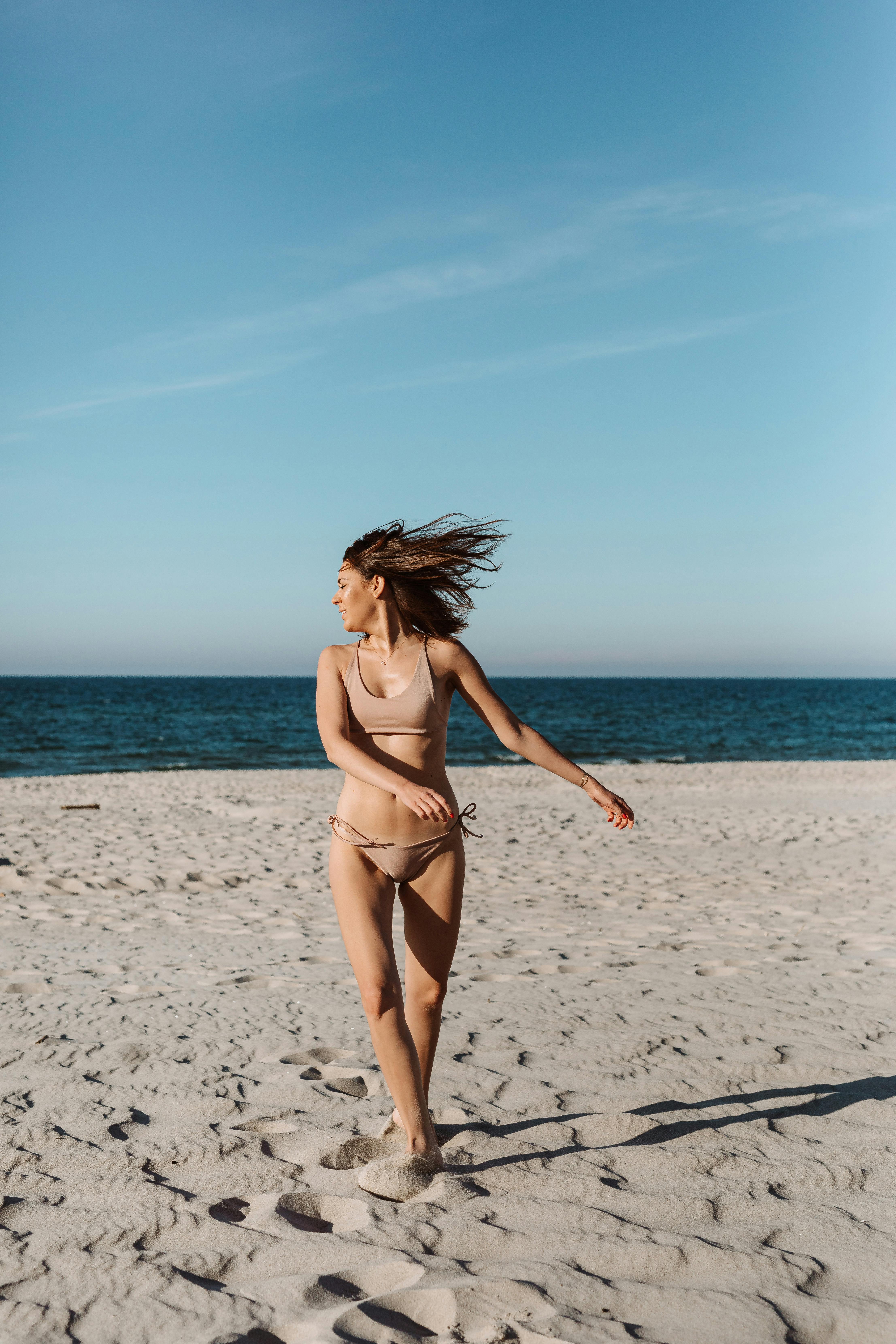 Woman in Brown Bikini Standing on Beach · Free Stock Photo