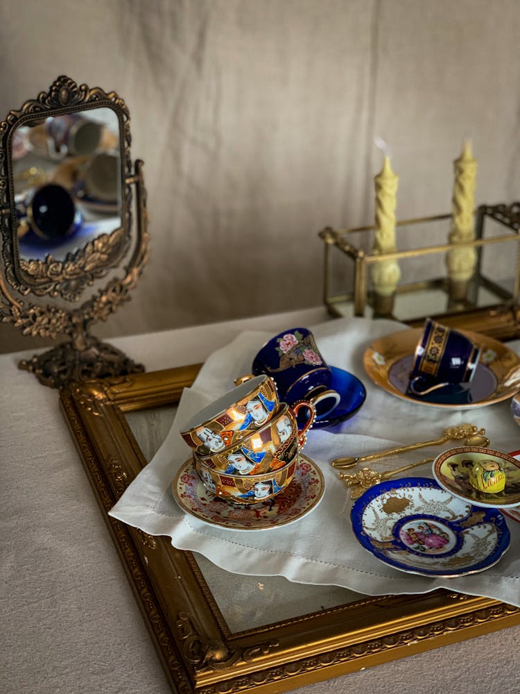 Tray With Dirty Cups And Saucers Near Candles And Mirror