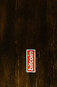 A prominent bitcoin sticker placed on a rustic wooden surface.