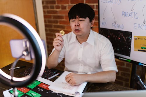 Male Vlogger holding a Gold Coin 