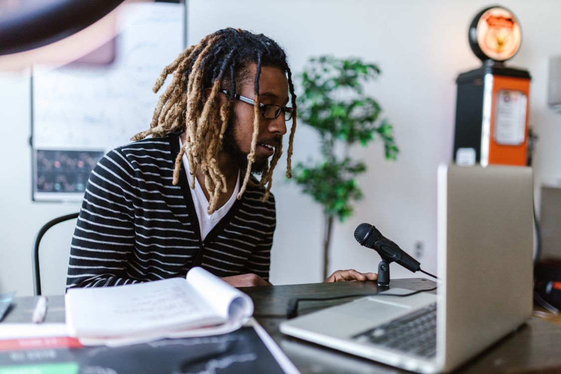 Man With Computer Microphone Man Sitting In Front of a Laptop and Microphone · Free Stock Photo