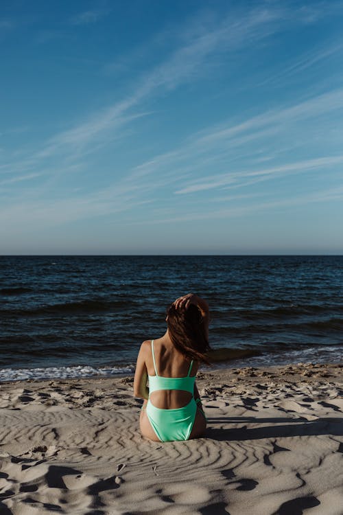 Kostenloses Stock Foto zu auf dem boden sitzen, bikini, blauer himmel