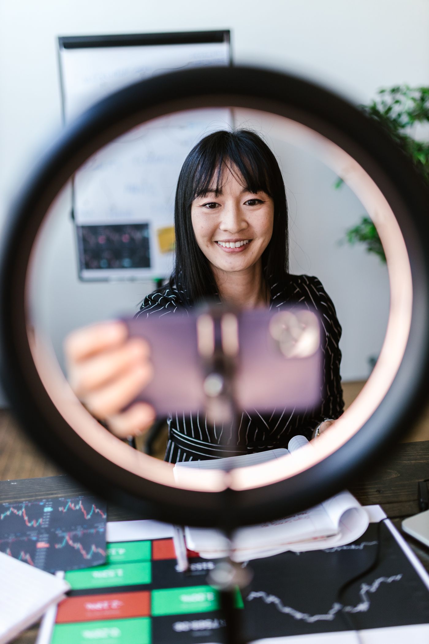 Creator recording smartphone video with a ring light in a professional workspace