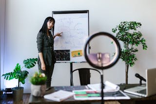 A Woman Standing while Pointing Her Finger on the Whiteboard