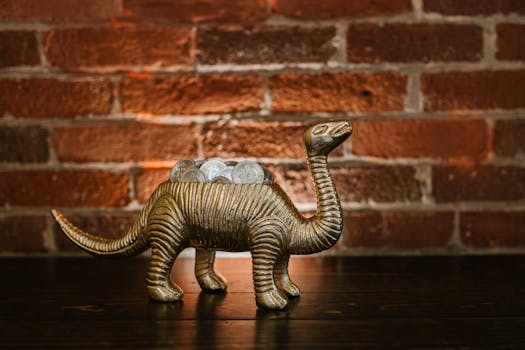 A charming dinosaur coin bank filled with coins set against a rustic brick wall.
