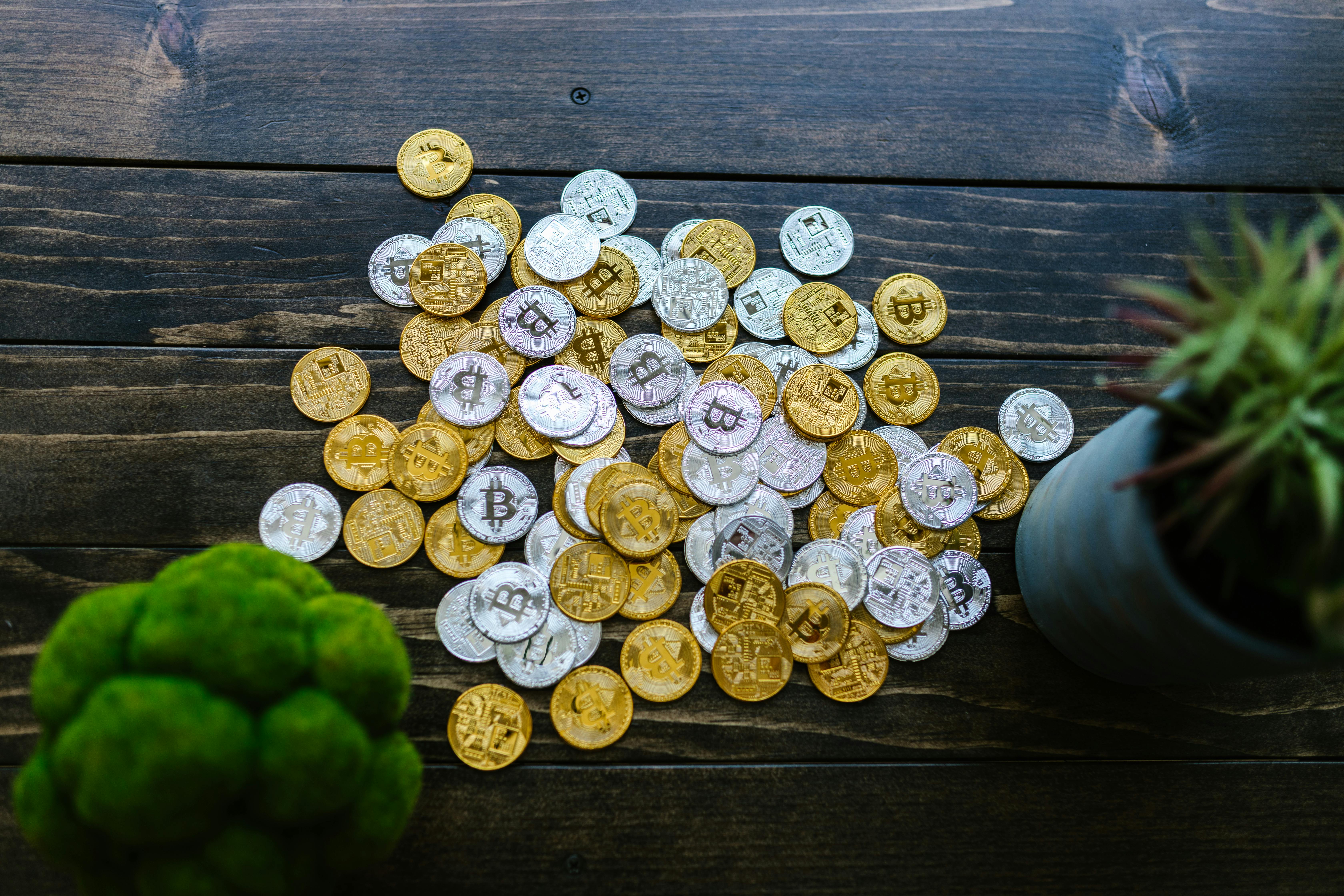silver and gold round coins on wooden surface