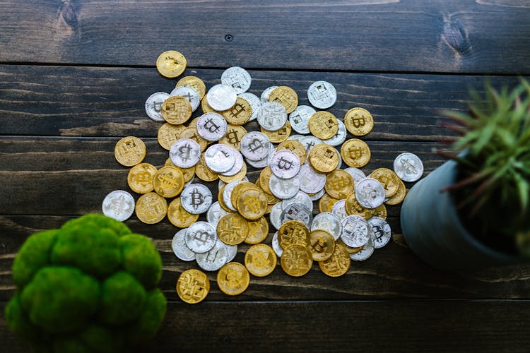 Silver And Gold Round Coins On Wooden Surface